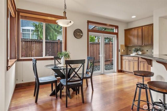 dining space featuring french doors, light wood finished floors, recessed lighting, and baseboards