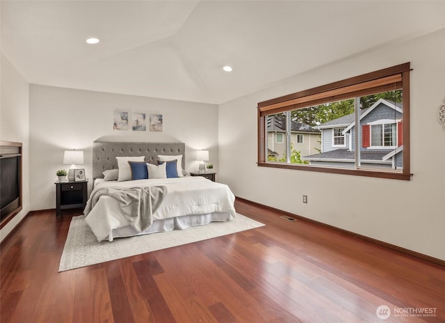 bedroom with wood finished floors, vaulted ceiling, baseboards, and recessed lighting