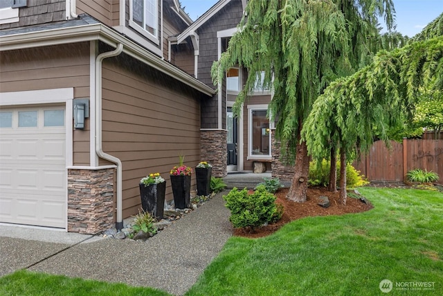 doorway to property featuring stone siding and a garage