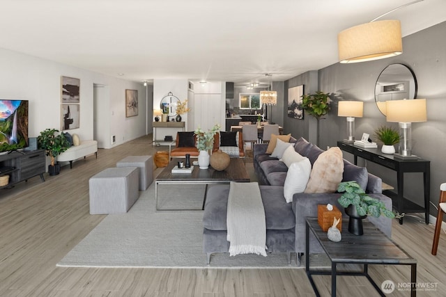 living area with a chandelier and wood finished floors