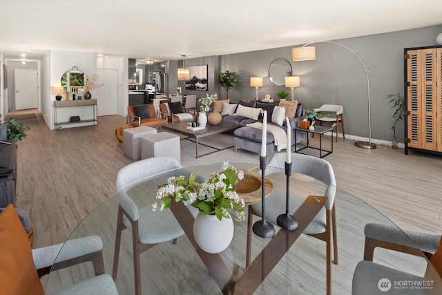 living area featuring light wood-style flooring and baseboards
