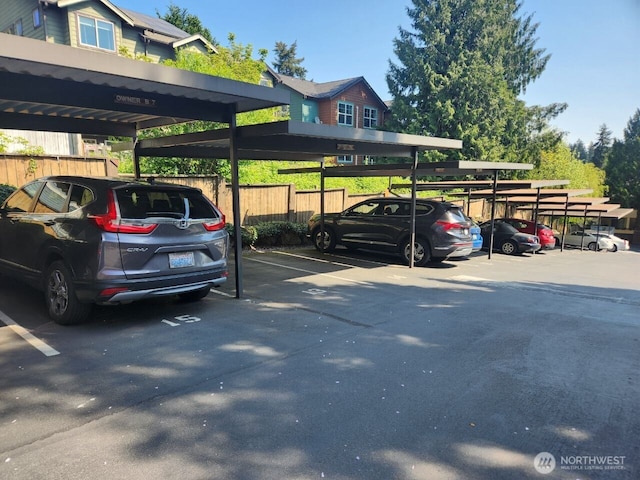 covered parking lot featuring fence