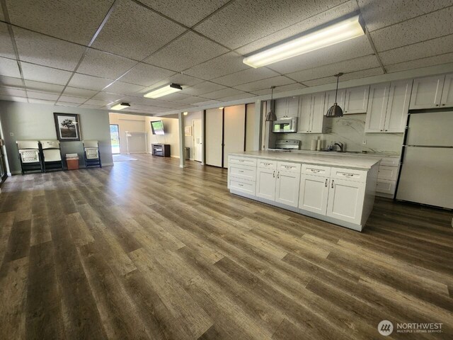 13259 15th Ave NE Unit B7, Seattle, WA 98125 - kitchen with white appliances, light countertops, open floor plan, a drop ceiling, and dark wood-style flooring