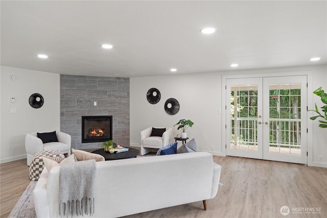 2419 Rocky Point Rd NW, Bremerton, WA 98312 - living room with wood finished floors, recessed lighting, baseboards, a tiled fireplace, and french doors