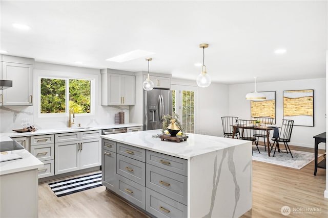 2419 Rocky Point Rd NW, Bremerton, WA 98312 - kitchen featuring stainless steel refrigerator with ice dispenser, a sink, gray cabinetry, light wood-style floors, and light stone counters