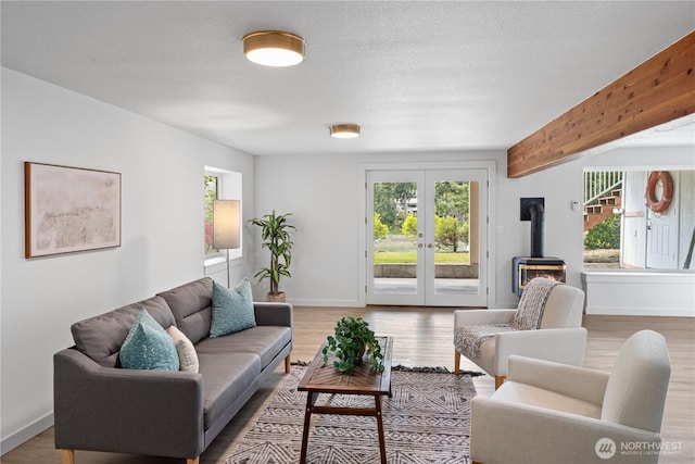 2419 Rocky Point Rd NW, Bremerton, WA 98312 - living area featuring a wood stove, plenty of natural light, french doors, baseboards, and a textured ceiling