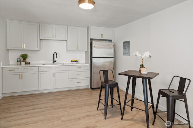 2419 Rocky Point Rd NW, Bremerton, WA 98312 - kitchen featuring freestanding refrigerator, a sink, electric panel, light countertops, and light wood-style flooring