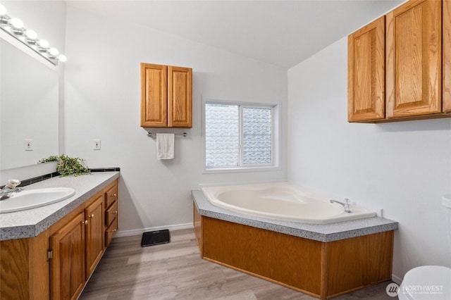 5211 S Aspen, Spokane, WA 99224 - full bathroom featuring vaulted ceiling, vanity, a bath, wood finished floors, and baseboards
