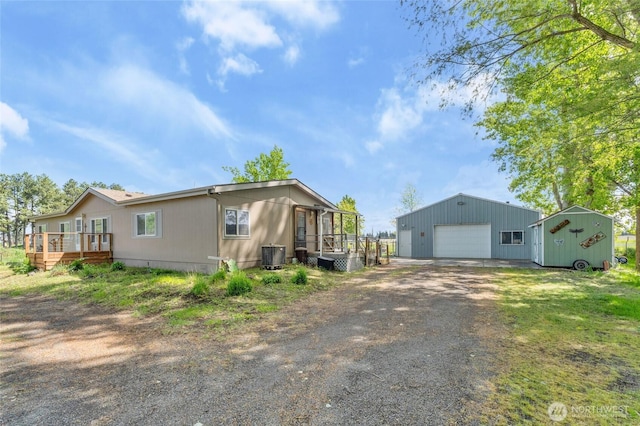 5211 S Aspen, Spokane, WA 99224 - view of front of house featuring central AC unit, an outbuilding, a garage, asphalt driveway, and a deck