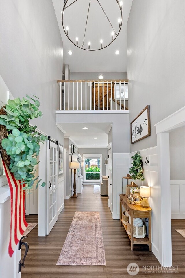 191 E Sterling Dr, Allyn, WA 98524 - entryway featuring a high ceiling, wood finished floors, recessed lighting, a chandelier, and wainscoting