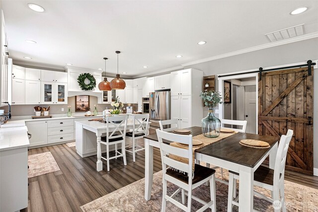 191 E Sterling Dr, Allyn, WA 98524 - dining space with crown molding, recessed lighting, light wood-style floors, and a barn door