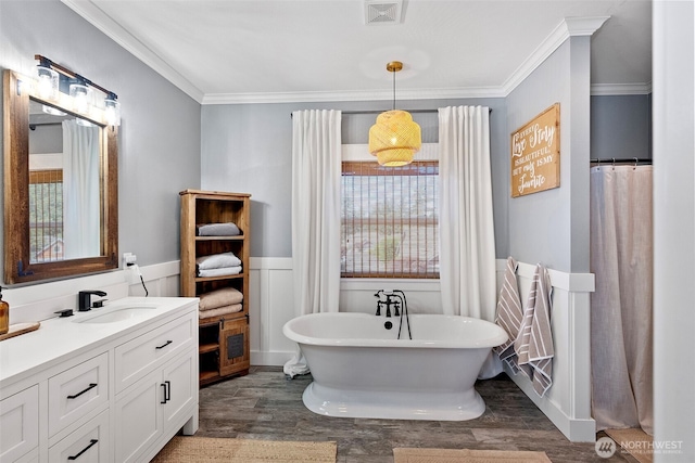 191 E Sterling Dr, Allyn, WA 98524 - bathroom featuring ornamental molding, wood finished floors, a freestanding bath, wainscoting, and vanity