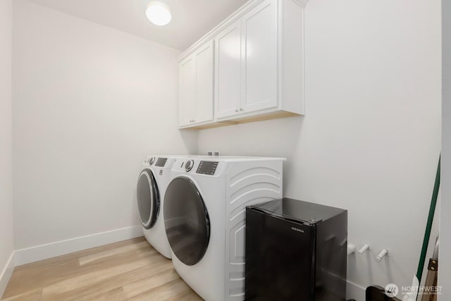 28611 NE 155th St, Duvall, WA 98019 - laundry room featuring washing machine and clothes dryer, cabinet space, light wood-style floors, and baseboards