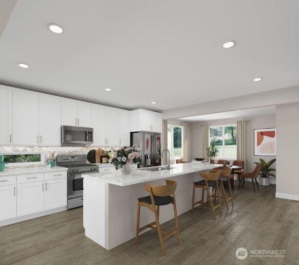 13214 NE 127th Ct Unit E, Kirkland, WA 98034 - kitchen with stainless steel appliances, a kitchen island with sink, decorative backsplash, light wood finished floors, and recessed lighting