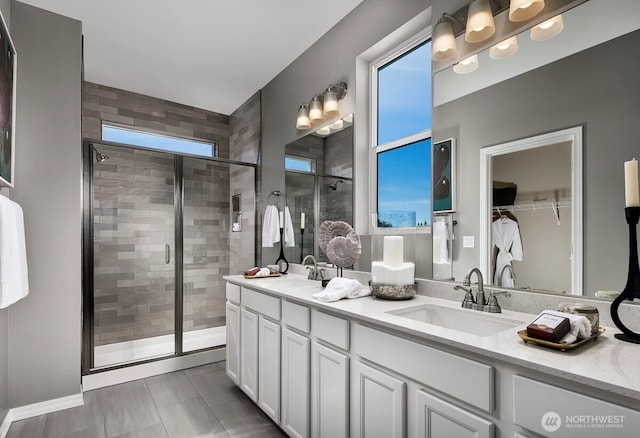 full bathroom featuring healthy amount of natural light, a shower stall, and double vanity