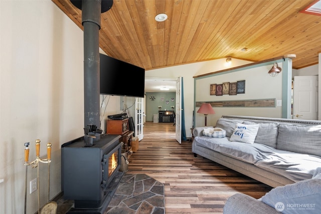 living room with a wood stove, wooden ceiling, wood finished floors, and vaulted ceiling