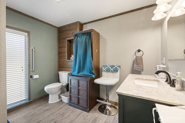 bathroom with ornamental molding, wood finished floors, toilet, and vanity