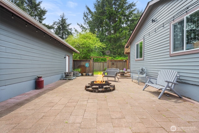 view of patio / terrace featuring an outdoor fire pit and fence