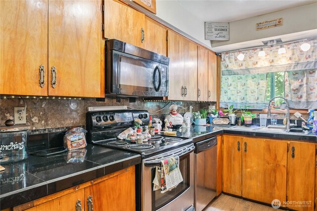 1016 Oak, Kelso, WA 98626 - kitchen featuring stainless steel electric range, black microwave, dishwasher, a sink, and decorative backsplash