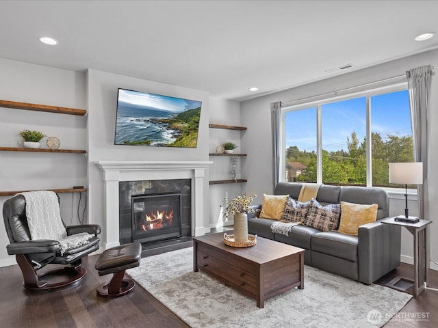 living room featuring wood finished floors, a tile fireplace, recessed lighting, and baseboards