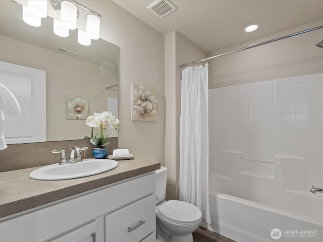 bathroom featuring toilet, shower / bathtub combination with curtain, and vanity
