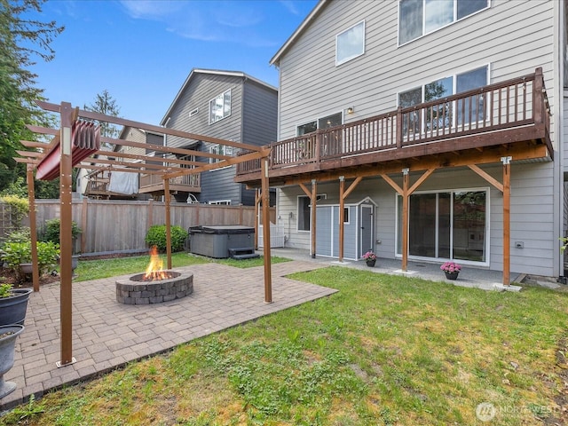 rear view of house featuring a hot tub, a fire pit, a patio, and a wooden deck