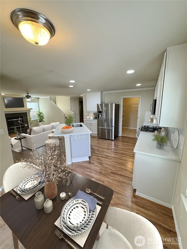 dining area featuring wood finished floors, recessed lighting, a ceiling fan, and baseboards