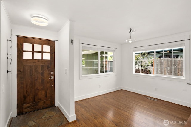 foyer featuring baseboards and wood finished floors