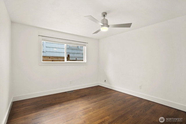unfurnished room featuring baseboards, dark wood-type flooring, and a ceiling fan