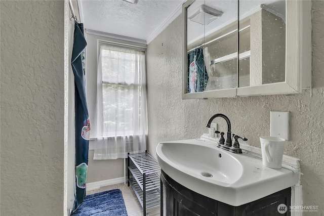 bathroom featuring a textured wall, a textured ceiling, crown molding, vanity, and tile patterned flooring