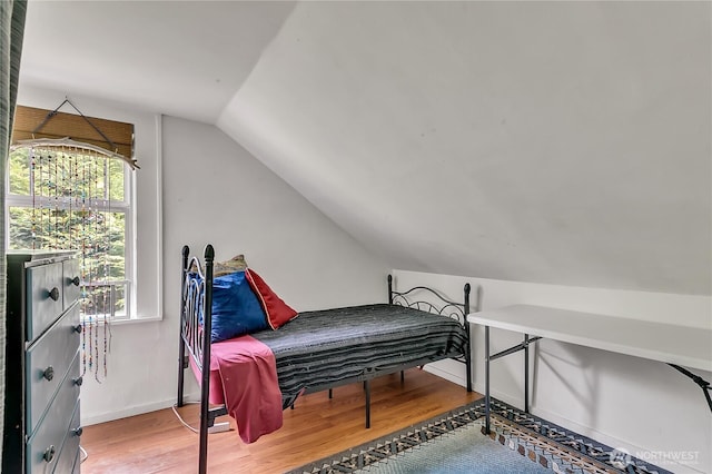bedroom featuring vaulted ceiling, wood finished floors, and baseboards