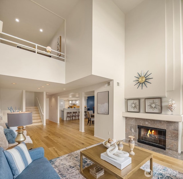 2400 Aurora Ave N Unit 202, Seattle, WA 98109 - living area featuring a towering ceiling, wood finished floors, a tile fireplace, stairway, and recessed lighting