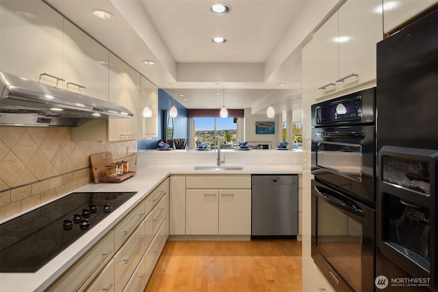 2400 Aurora Ave N Unit 202, Seattle, WA 98109 - kitchen featuring black appliances, a sink, under cabinet range hood, light countertops, and recessed lighting