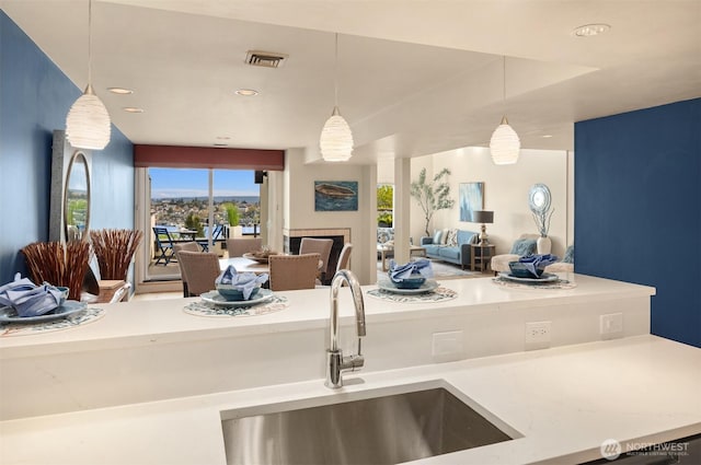 2400 Aurora Ave N Unit 202, Seattle, WA 98109 - kitchen featuring open floor plan, a sink, decorative light fixtures, light countertops, and recessed lighting