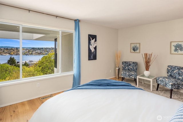 2400 Aurora Ave N Unit 202, Seattle, WA 98109 - bedroom featuring baseboards, a water view, and wood finished floors