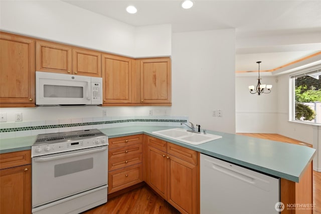 5007 70th Avenue Ct W Unit 7A, University Place, WA 98467 - kitchen featuring white appliances, a sink, a peninsula, light wood finished floors, and a chandelier