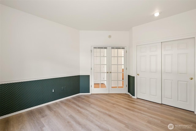 5007 70th Avenue Ct W Unit 7A, University Place, WA 98467 - unfurnished bedroom with a wainscoted wall, wood finished floors, french doors, and a closet