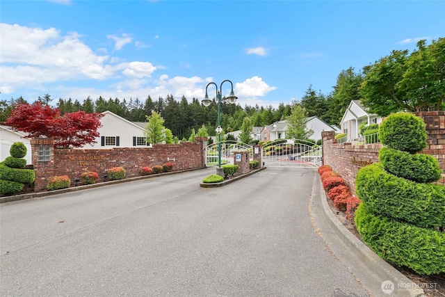 5007 70th Avenue Ct W Unit 7A, University Place, WA 98467 - view of asphalt street with street lights, curbs, a gate, a residential view, and a gated entry