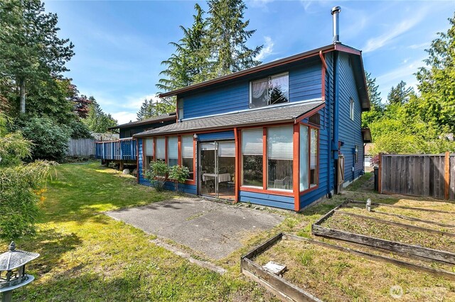 15915 SE 166th Pl, Renton, WA 98058 - rear view of house featuring a vegetable garden, a sunroom, a patio area, and roof with shingles