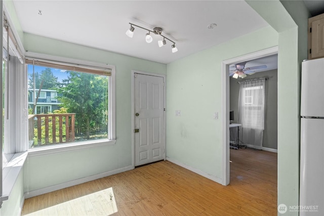 entryway featuring baseboards, plenty of natural light, and light wood-style flooring