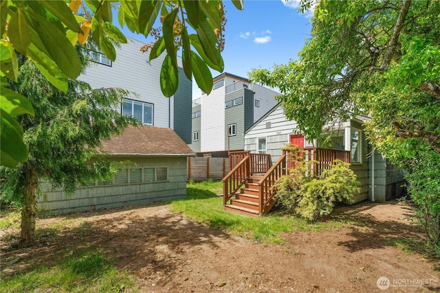 rear view of house featuring a wooden deck and fence