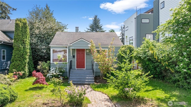 view of front of home featuring a shingled roof and a chimney