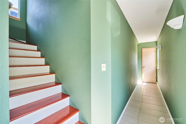 staircase featuring baseboards and tile patterned floors