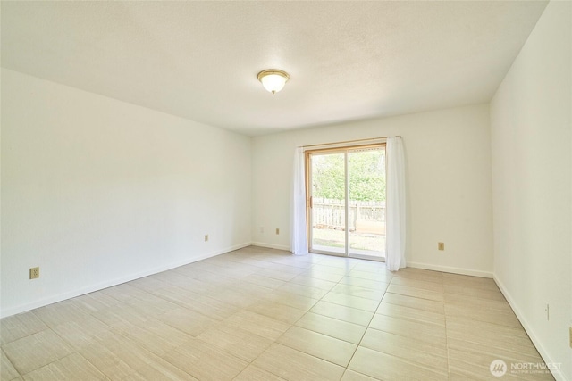 spare room with baseboards