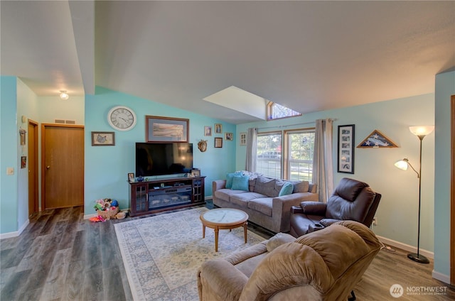 1510 144th Ln, Long Beach, WA 98631 - living room with a skylight, wood finished floors, vaulted ceiling, and baseboards