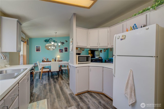 1510 144th Ln, Long Beach, WA 98631 - kitchen featuring freestanding refrigerator, stainless steel microwave, a sink, light countertops, and a chandelier