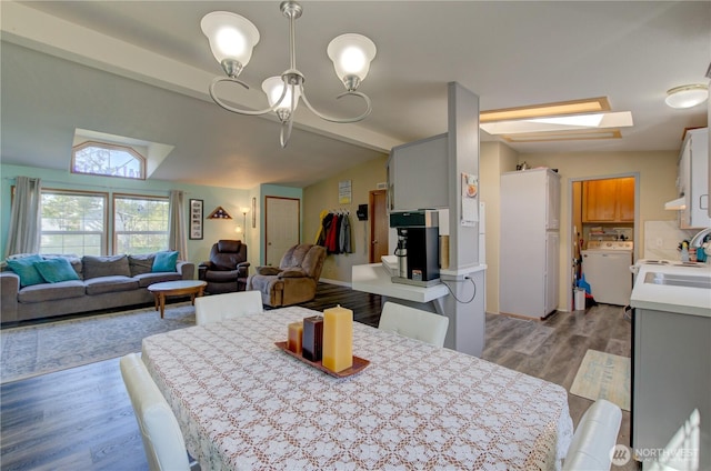 1510 144th Ln, Long Beach, WA 98631 - dining area featuring washer / clothes dryer, a chandelier, and wood finished floors