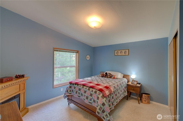 1510 144th Ln, Long Beach, WA 98631 - carpeted bedroom featuring vaulted ceiling, baseboards, a closet, and a fireplace