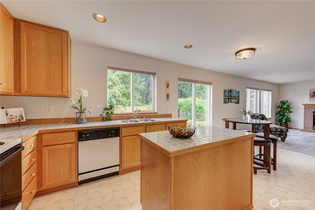 5511 152nd St SE, Everett, WA 98208 - kitchen featuring white dishwasher, a sink, tile counters, healthy amount of natural light, and recessed lighting