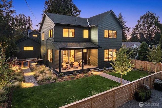 10419 41st Ave SW Unit A, Seattle, WA 98146 - back of property at dusk with a shingled roof, a wooden deck, and an outdoor hangout area